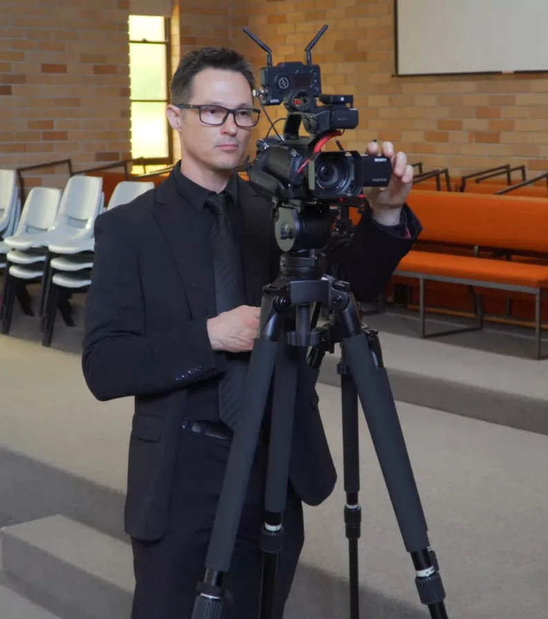 Stream Catcher's operator set up with a professional camera to live stream a service
